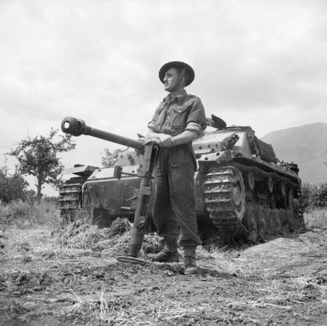 F. Jefferson standing in front of a Sturmgeschütz III with a PIAT