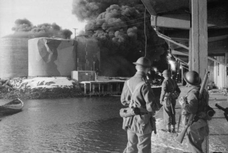 British soldiers looking at a building shrouded in smoke