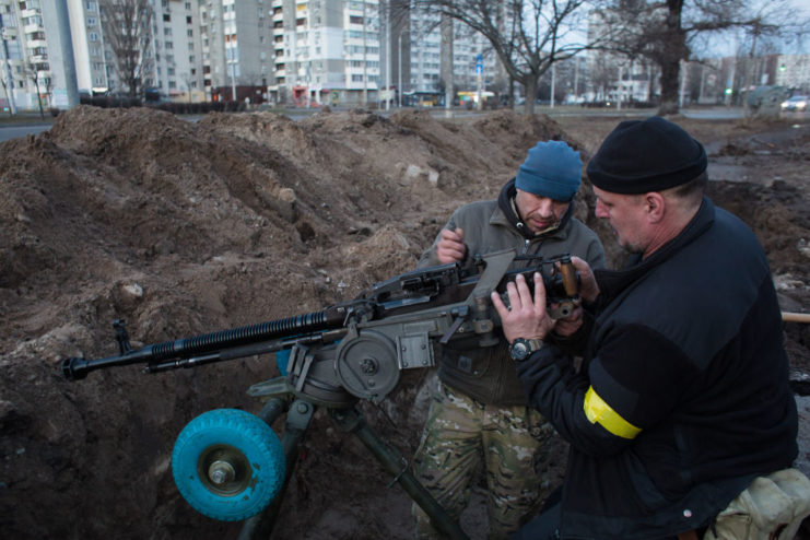 Members of the Territorial Defence Forces setting up a machine gun in a trench