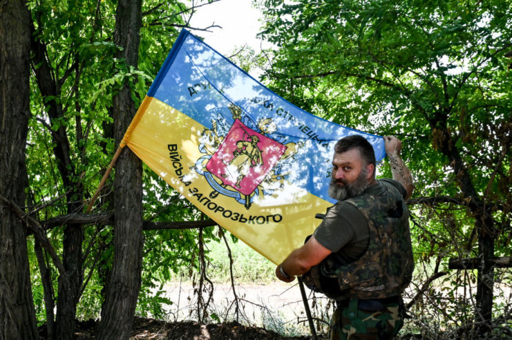 Member of the Territorial Defence Forces standing with the Ukrainian flag
