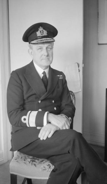 John Henry Godfrey sitting in a chair while dressed in full naval uniform