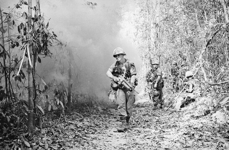 Three members of the US 1st Cavalry Division walking along a path in the Vietnamese jungle