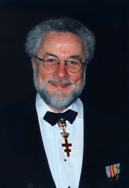 Adrian Cronauer wearing a suit, with his military medals on his chest