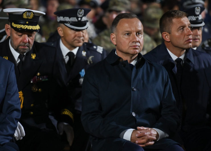 Andrzej Duda sitting among officials