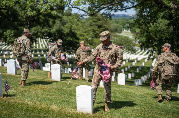 US Air Force airmen placing American flags on gravestones at Arlington National Cemetery