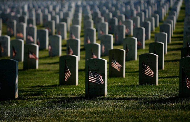 Small American flags placed in front of gravestones
