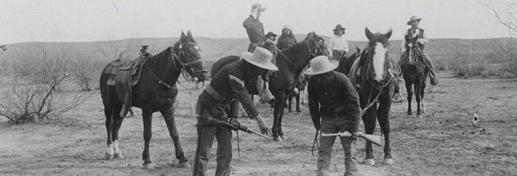 Soldiers and Indian Scouts standing with their horses