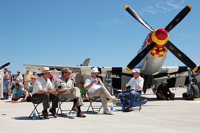 Bud Anderson sitting with three others in front of his North American P-51D Mustang "Old Crow"