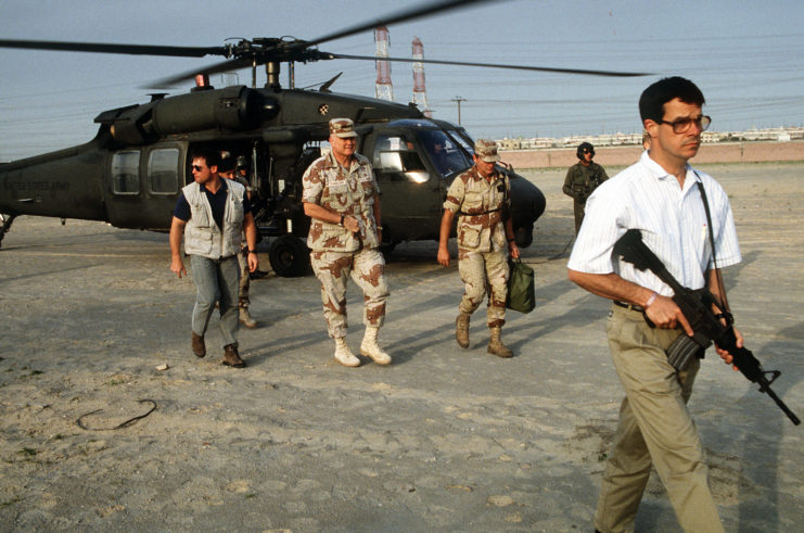 Norman Schwarzkopf being escorted off a helicopter by a group of Delta Force bodyguards