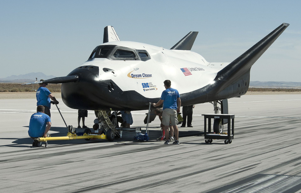 Three Sierra Space employees working around the Dream Chaser