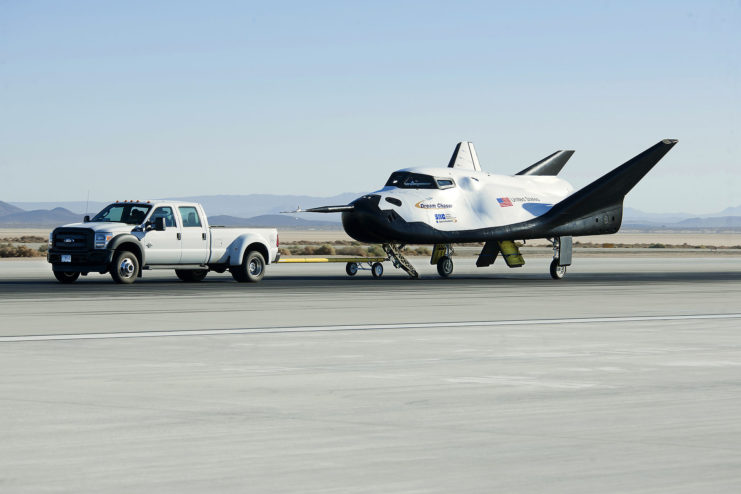 Pickup truck towing the Dream Chaser down the runway