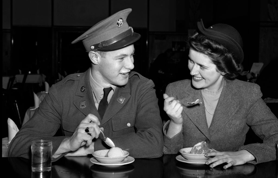 US soldier and a woman eating ice cream at a table