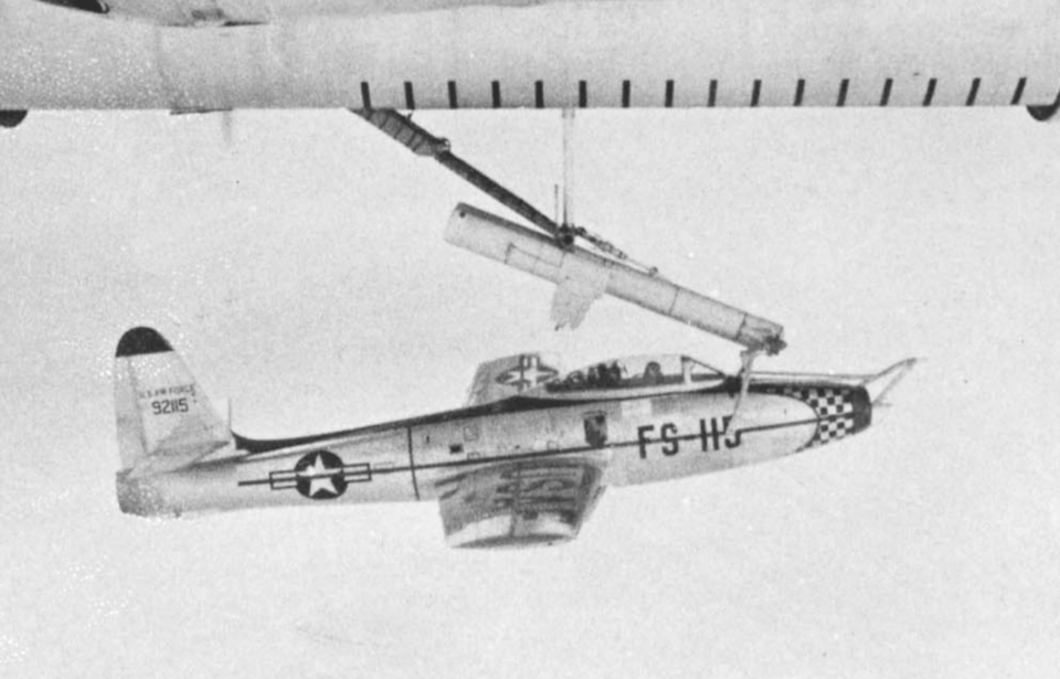 Republic F-84E Thunderjet attached to the bottom of a larger bomber via a trapeze