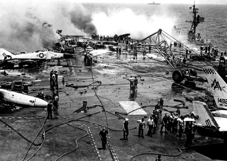 Smoke and damaged aircraft on the deck of the USS Forrestal (CV-59)