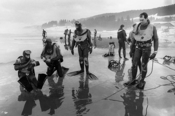 Gendarmerie nationale members standing on a beach in diving gear