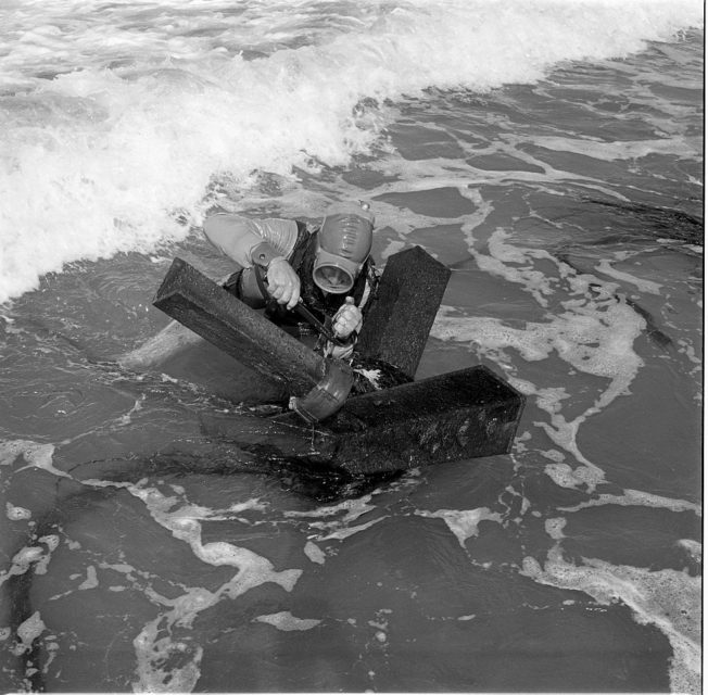 Frogman working on a metal beach obstruction