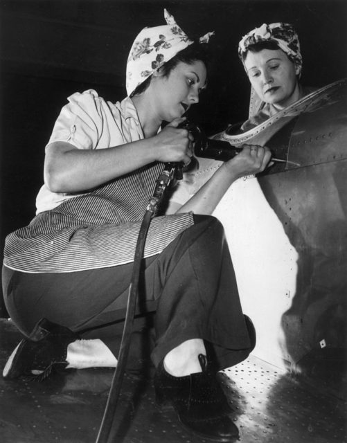 Two women constructing an aircraft in a factory