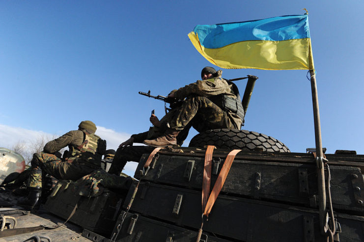 Two Ukrainian soldiers sitting in full uniform