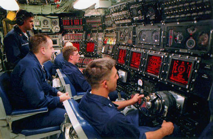 Five sailors using the US Navy Submarine Combat Control System