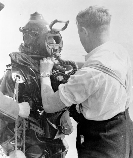 Man adjusting Lionel Crabb's diving suit