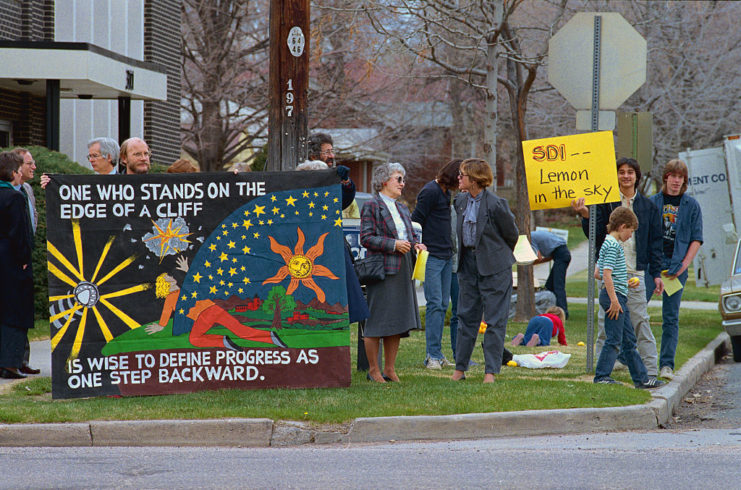 Protesters holding signs on a street corner