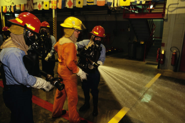 US Navy recruits operating a firehose 