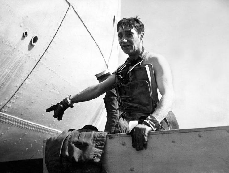 Lionel Crabb wearing diving gear and pointing at something off-camera