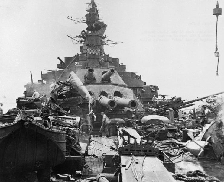 Man walking across the damaged stern of the USS Nevada (BB-36)