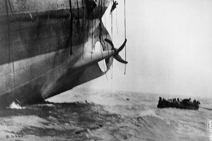 Lifeboat floating next to a larger sinking vessel