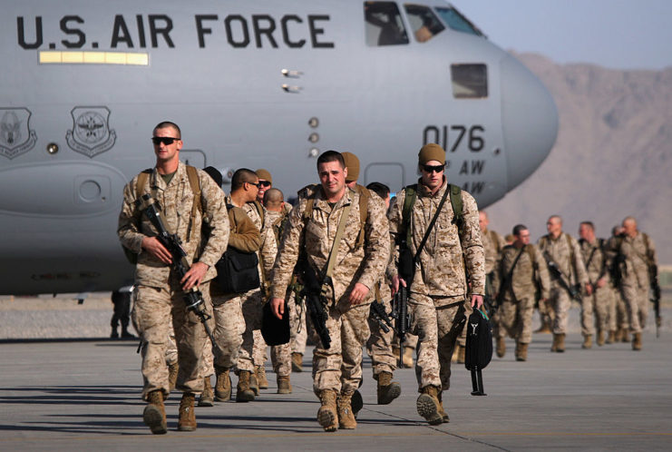 Group of US troops walking away from an aircraft