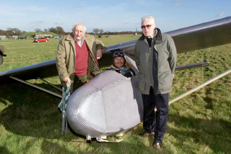 John "Jack" Best and Bill Goldfinch standing next to a replica of the Colditz Cock, with pilot John Lee sitting in the cockpit