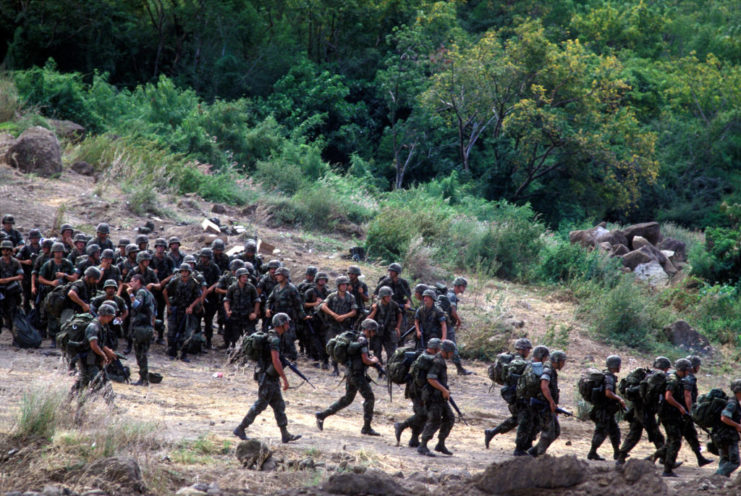 American soldiers walking down the side of a muddy hill