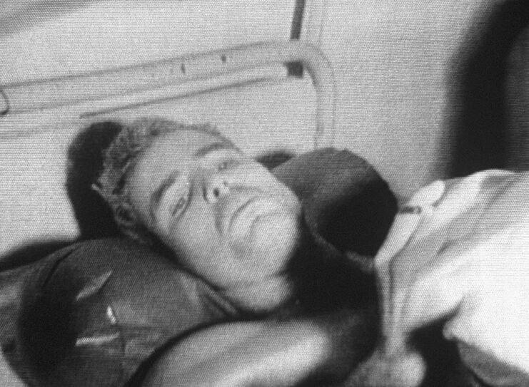 John McCain lying in a hospital bed