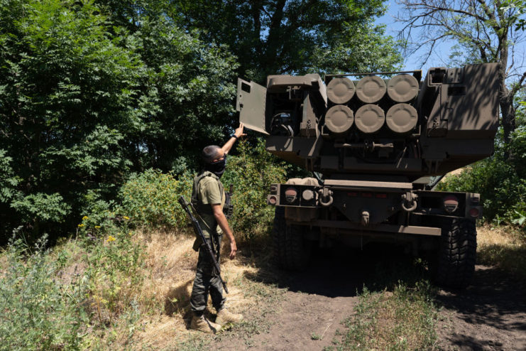 Ukrainian military commander standing behind an M142 HIMARS