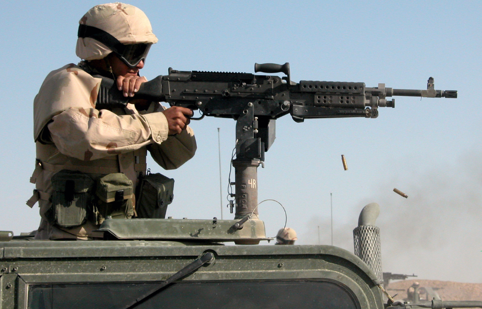 Seabee firing an M240B mounted atop a Humvee