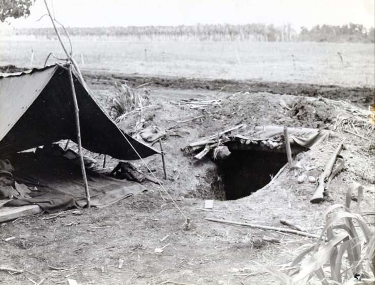 Tent set up beside a foxhole