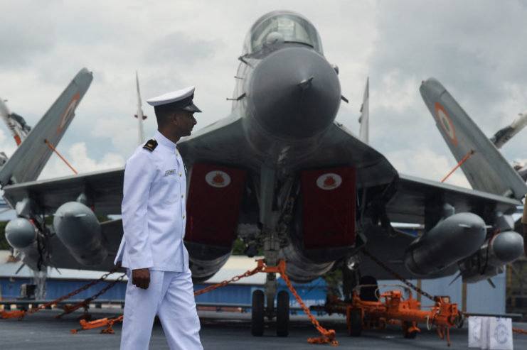 Indian Navy officer walking in front of a Mikoyan MiG-29K