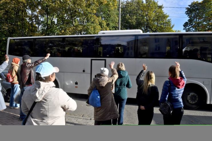 Group of women waving at a departing charter bus