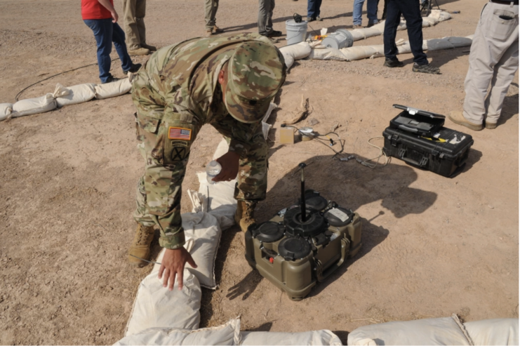 American soldier standing beside an XM204 top attack munition unit