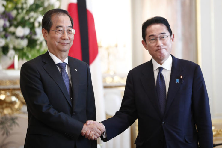 Han Duck-soo shaking hands with Fumio Kishida