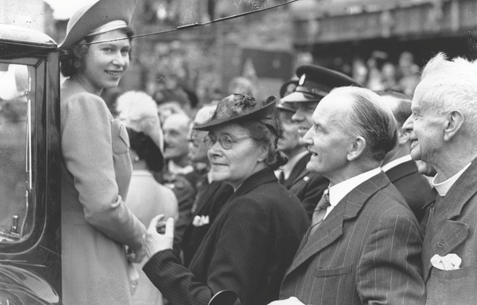 Queen Elizabeth II standing before a group of people