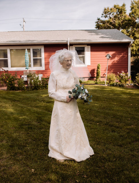 Frankie King wearing a wedding gown and holding a bouquet of flowers