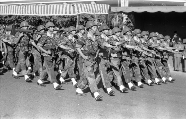 Moroccan soldiers walking in formation down a street while equipped with LRAC-50 73 mm bazookas