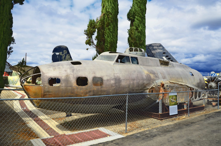 Hull of the "Swamp Ghost" on display behind a chain link fence