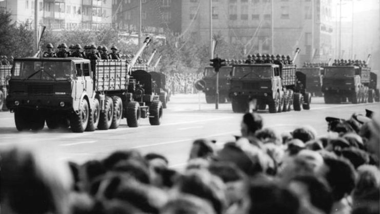 Crowd watching Tatra T813s towing KS-19s down a street