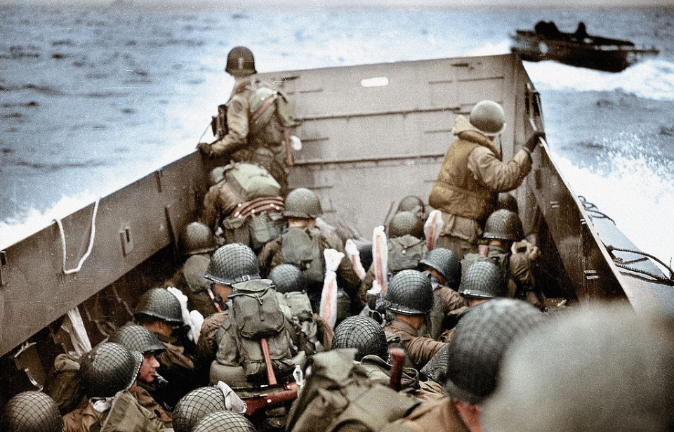 American soldiers sitting in a landing craft at sea