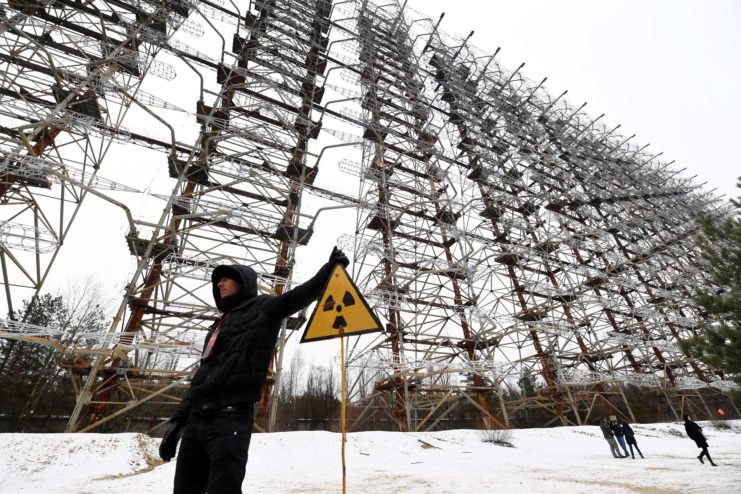 Man standing in front of a Duga radar system structure