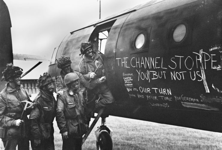 Five British paratroopers standing beside an aircraft