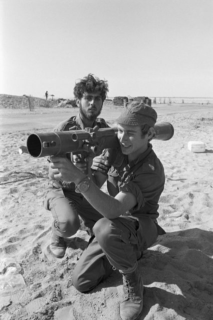 Israeli soldier aiming a launcher while another crouches beside him