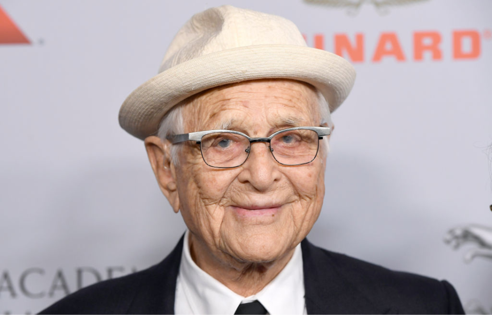 Norman Lear wearing a suit and hat